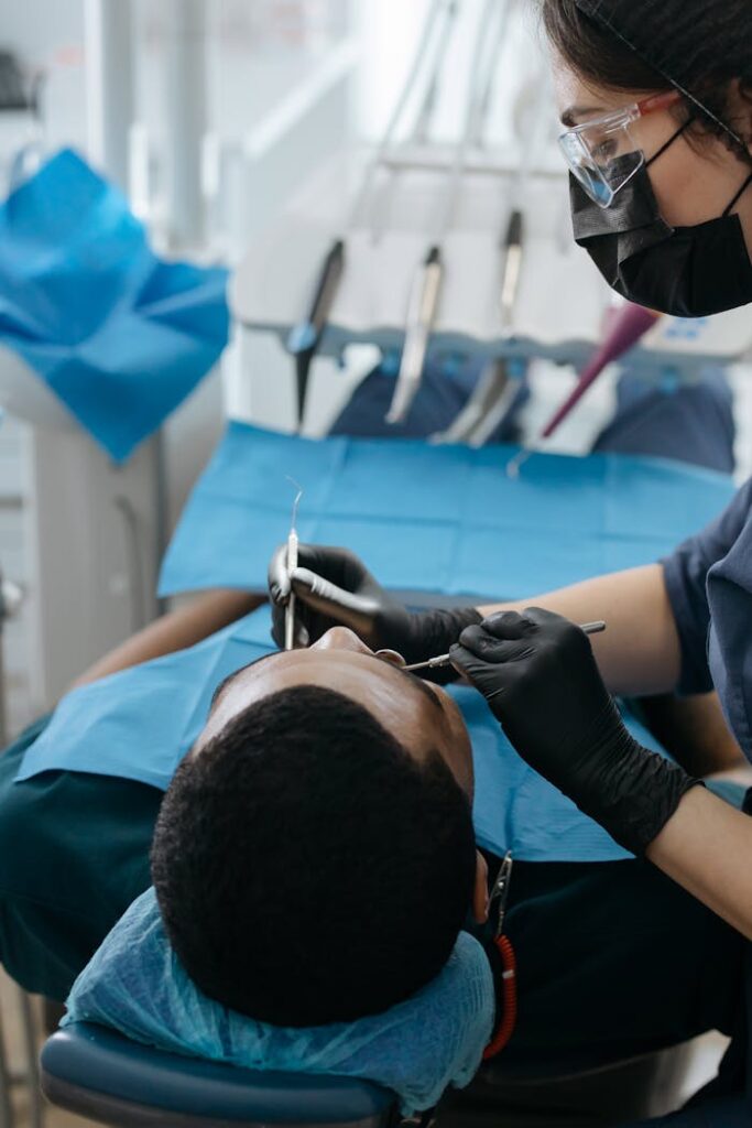 pexels-photo-6502630 A dentist performs a checkup on a patient in a dental clinic, focusing on oral health care.